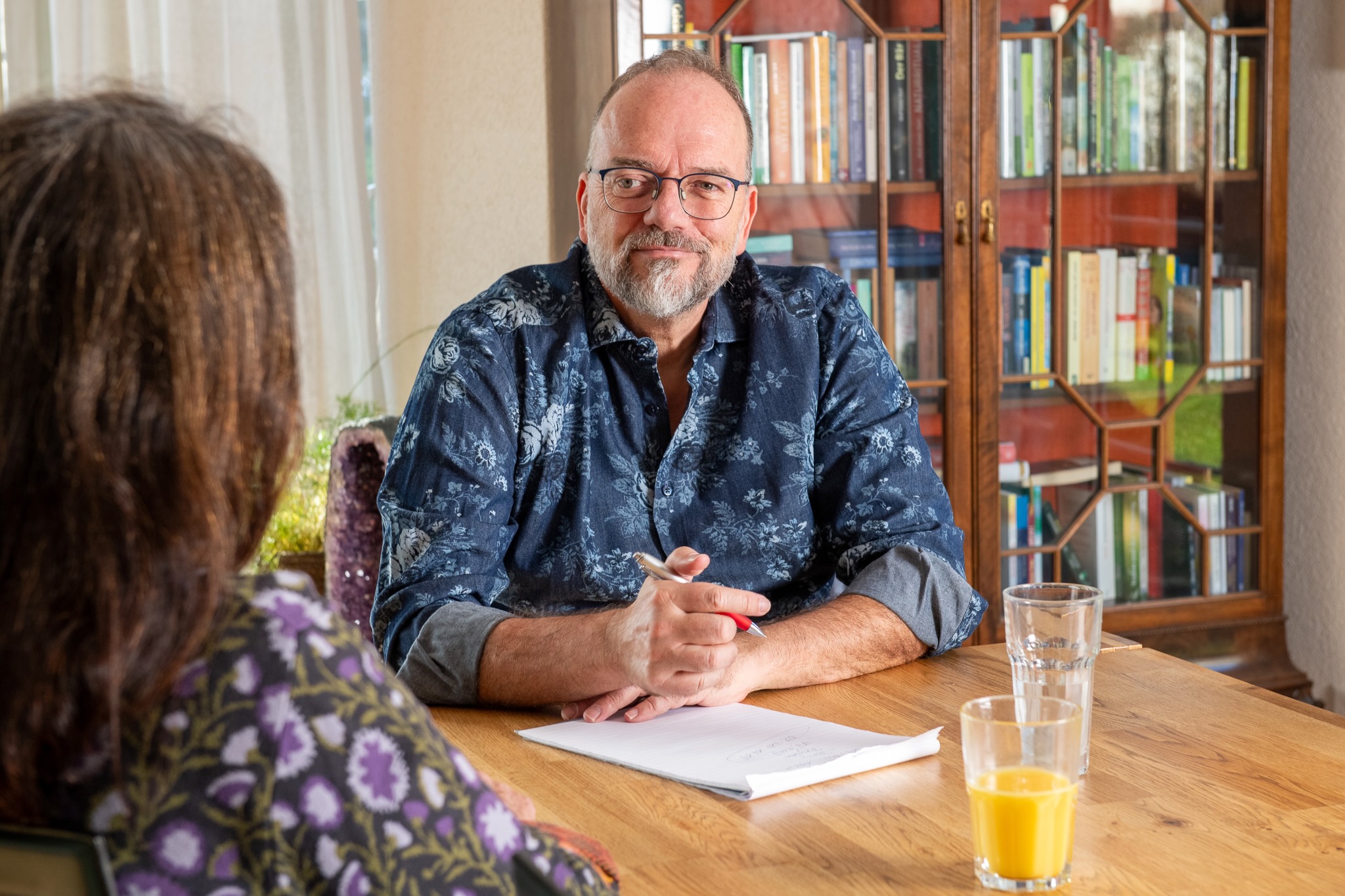 Urs-Micheal Hoenner am Tisch sitzend im Coaching-Gespräch mit einer Kundin